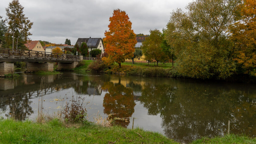 Bunter Herbstbaum spiegelt sich in der Vils