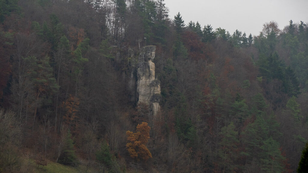 Felsnadel im bewaldeten Talhang